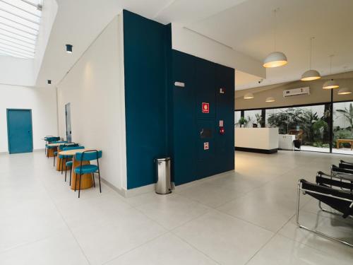 a room with tables and chairs and a blue wall at Apê Paulista Bela Cintra in Sao Paulo