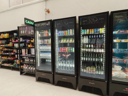 a store with four refrigerators with drinks and other beverages at Apê Paulista Bela Cintra in Sao Paulo