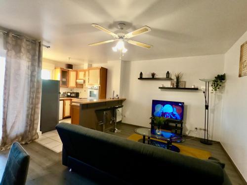 un salon avec un canapé et un ventilateur de plafond dans l'établissement Logement entier, à Savigny-sur-Orge