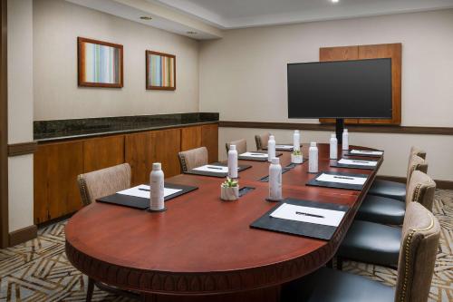 a conference room with a table and a flat screen tv at Hilton Phoenix Airport in Phoenix