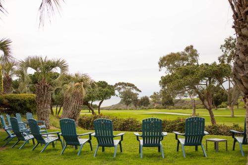 a group of chairs and tables with a golf course in the background at Hilton La Jolla Torrey Pines in San Diego