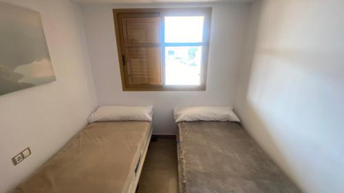 2 Betten in einem Zimmer mit Fenster in der Unterkunft Los Cerezos in Finestrat