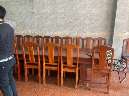 une table en bois entourée d'une rangée de chaises dans l'établissement Khách sạn MINH NHẬT, à Hô-Chi-Minh-Ville