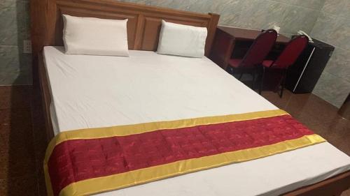 - un lit avec une couverture rouge et jaune dans l'établissement Khách sạn MINH NHẬT, à Hô-Chi-Minh-Ville