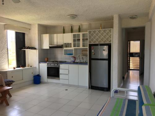 a kitchen with white cabinets and a black refrigerator at Porlamar La Reserve frente a La Vela in Porlamar
