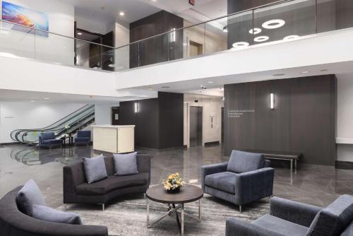 a lobby with couches and chairs and a staircase at Hilton Vancouver Metrotown in Burnaby