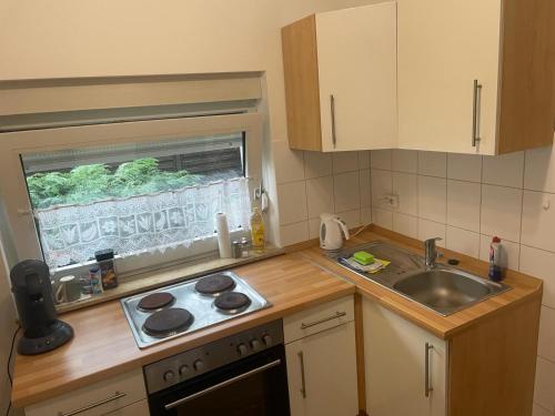 a kitchen with a sink and a stove and a window at Haus Check-In in Gütersloh