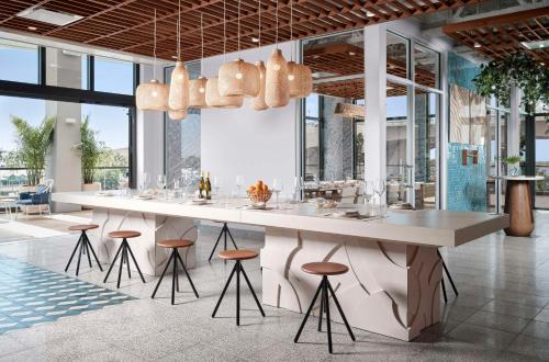 a dining room with a large white table and stools at Hilton Fort Lauderdale Marina in Fort Lauderdale