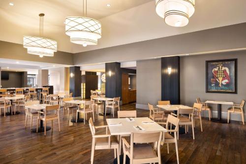 a dining room with tables and chairs and lights at Hilton Vancouver Airport in Richmond