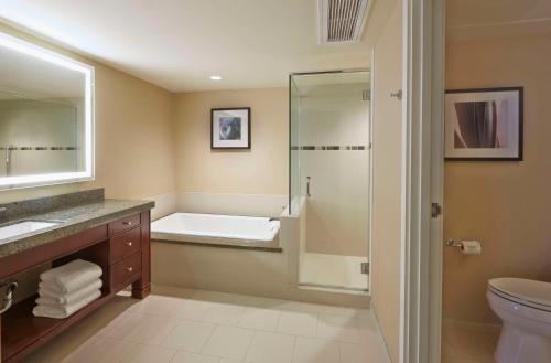 a bathroom with a shower and a toilet and a sink at Hilton Hawaiian Village Waikiki Beach Resort in Honolulu