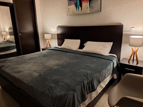 a bedroom with a large bed and a chair at Hotel Tao in Atlixco