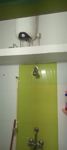 baño con puerta verde y lavamanos en LENKA BHAWAN, en Bhubaneshwar