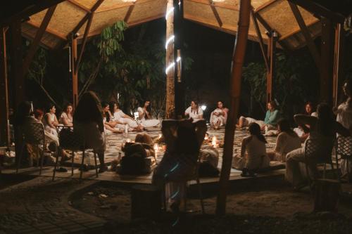 um grupo de pessoas sentadas em torno de um palco à noite em Villa Lu Amazon Ecolodge em Tarapoto