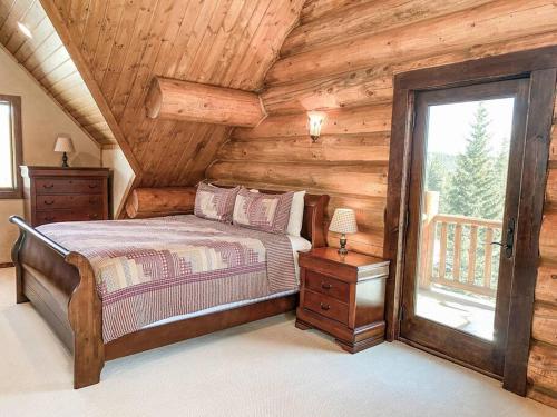 1 dormitorio con 1 cama en una cabaña de madera en Spectacular Custom Log Cabin with Hot Tub, Epic Views, Fireplace - Moose Tracks Cabin, en Fairplay