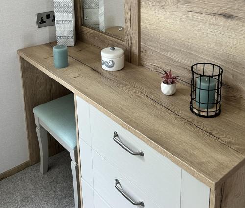 a bathroom vanity with a mirror and a blue stool at Sandy Toes, Padstow in Padstow