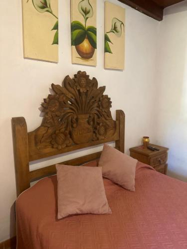 a bed with a wooden headboard in a bedroom at Hotel del Pozo in San Sebastián del Oeste