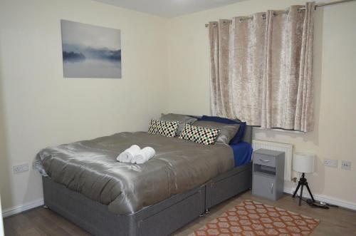 een slaapkamer met een bed met twee handdoeken erop bij Nice and Cosy Flat in London/Ilford/Barking, United Kingdom in Barking