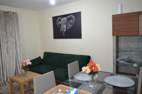 een woonkamer met een groene bank en een tafel bij Nice and Cosy Flat in London/Ilford/Barking, United Kingdom in Barking