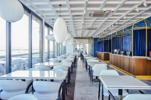 a dining room with white tables and white chairs at Park Inn by Radisson Yalova City Center in Yalova