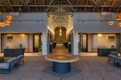 a lobby with a table in the middle of a room at Radisson Safari Hotel Hoedspruit in Hoedspruit