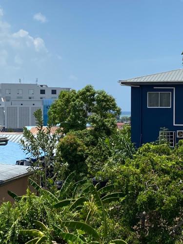 vista su un edificio blu e su alcuni alberi di 1 Bedroom Apartment, in Coconut Drive San Fernando a San Fernando