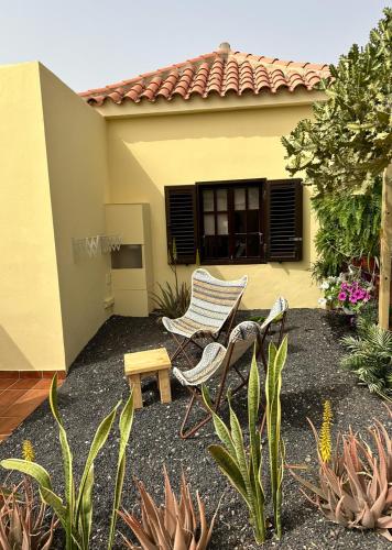 a patio with two chairs and a table in front of a house at Casa La Pepita Las Lomas 117 in Caleta De Fuste