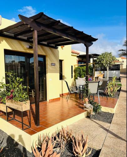 a wooden deck with a pergola on a house at Casa La Pepita Las Lomas 117 in Caleta De Fuste