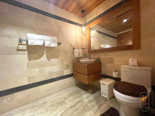 a bathroom with a toilet and a mirror at Suites Presidencial Boca chica in Cuevas