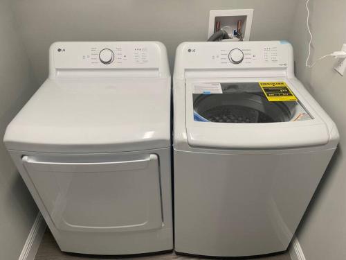 a washing machine and a washer in a room at Modern and comfortable new home with hot tub in Fort Pierce