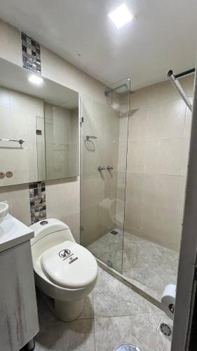 a bathroom with a toilet and a glass shower at Rivière Boutique Hotel in Medellín