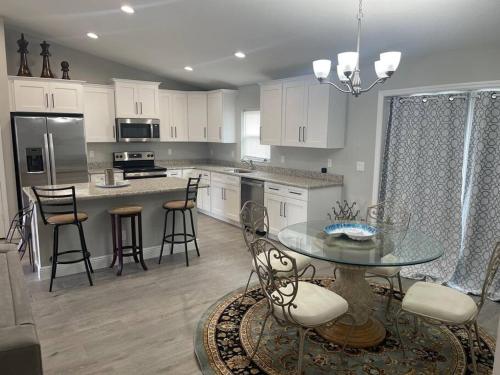 a large kitchen with a glass table and chairs at Modern and comfortable new home with hot tub in Fort Pierce
