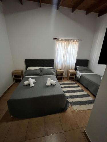 een slaapkamer met een bed met twee handdoeken erop bij Hospedaje L H Ezeiza B in Ezeiza