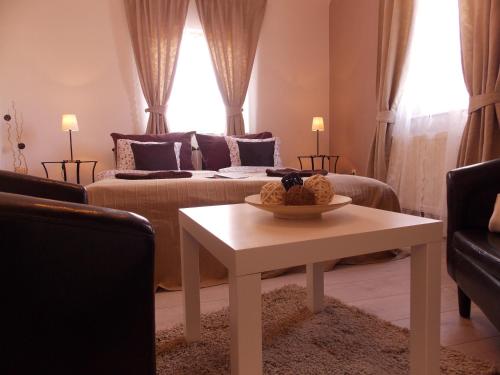 a living room with a couch and a table at Éden Villa Apartmanház in Balatonfüred