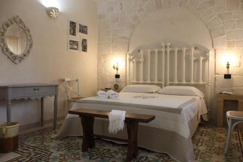 1 dormitorio con cama, mesa y espejo en Masseria Tolla, en Ostuni