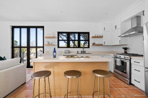 a kitchen with a island with three bar stools at Las Luces in Spicewood