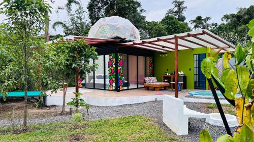 una casa con pérgola en un jardín en Macas Glamping, en Macas