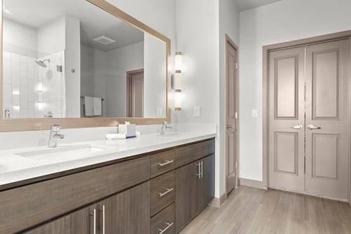 a bathroom with a sink and a large mirror at 3BR Cozysuites RORO Pool, Pets, Parking 7&13 in Phoenix