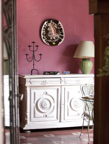 a white cabinet in a room with a plate on the wall at Le Mas des Citronniers in Collioure