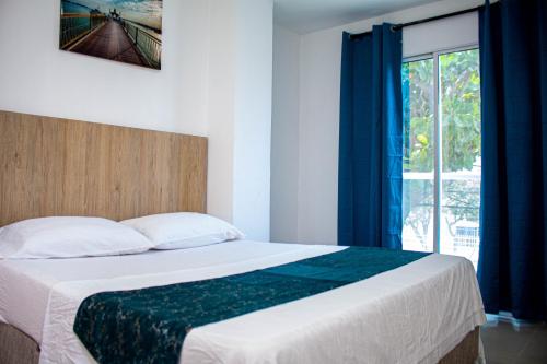 um quarto com uma cama grande e uma janela em Hotel Horizon In em Santa Marta