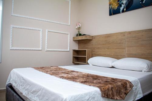 um quarto com uma cama grande e uma cabeceira em madeira em Hotel Horizon In em Santa Marta