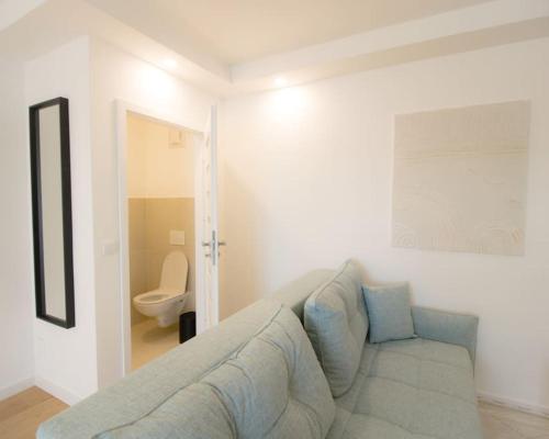 a white living room with a couch and a toilet at Charming Apartment in Heart of Vienna JOS 20 in Vienna