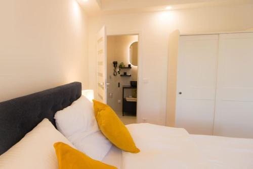 a bedroom with a white bed with yellow pillows at Charming Apartment in Heart of Vienna JOS 20 in Vienna