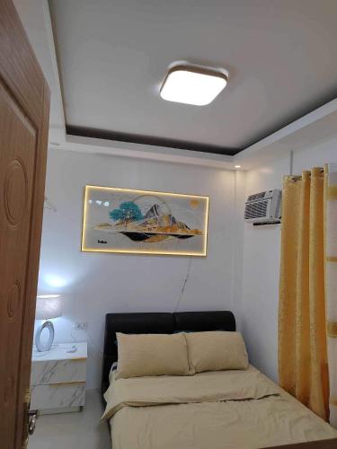 a bedroom with a bed and a painting on the wall at JILY’s Transient Tiny House in Bayugan City