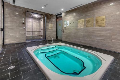 a jacuzzi tub in a large bathroom with at Luxury 2BR - Subway/Pool/Gym/Sauna + Free Parking in Toronto