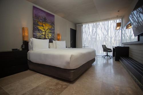 a hotel room with a large bed and a desk at Courtyard by Marriott Tuxpan Veracruz in Tuxpan de Rodríguez Cano