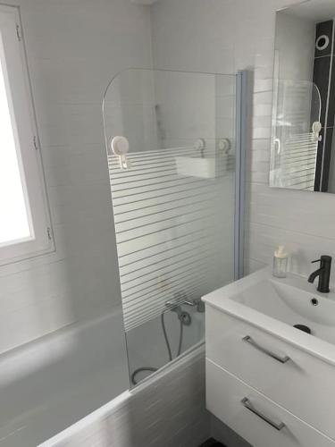 a white bathroom with a sink and a shower at Maison très agréable. in Saint-Fons