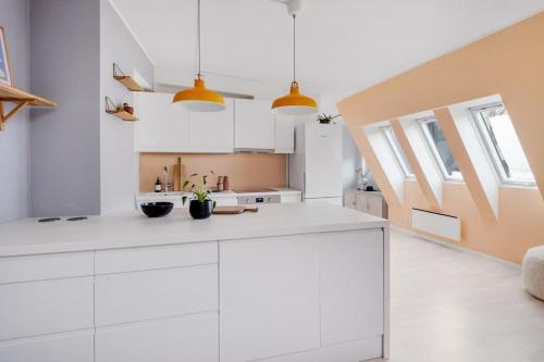 una cocina blanca con armarios blancos y ventanas en Loft in the middle of Oslo City Center -2 bedrooms, en Oslo