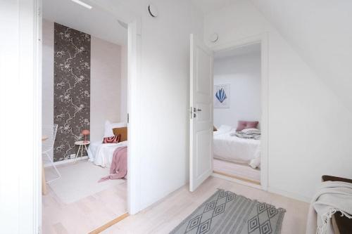 a white room with a bedroom with two beds at Loft in the middle of Oslo City Center -2 bedrooms in Oslo