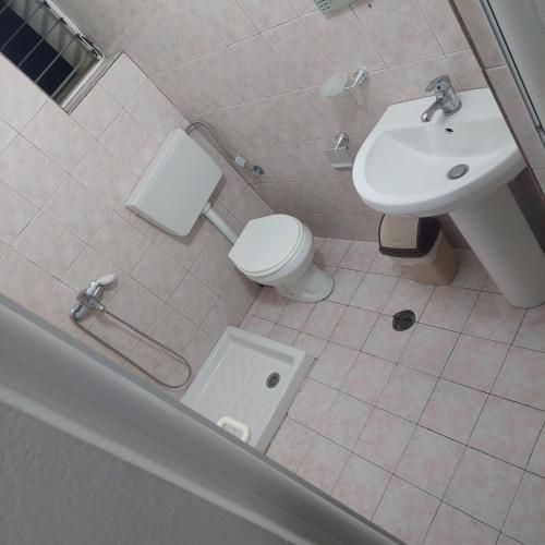 a bathroom with a toilet and a sink at Hostel Casa Mia SR in Sarandë