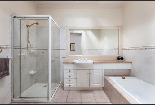 a bathroom with a shower and a sink and a tub at Luxurious Townhouse Retreat in Prestigious Brighton in Melbourne